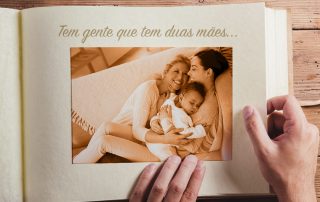 Imagem de um álbum de foto com duas mães abraçando um bebê